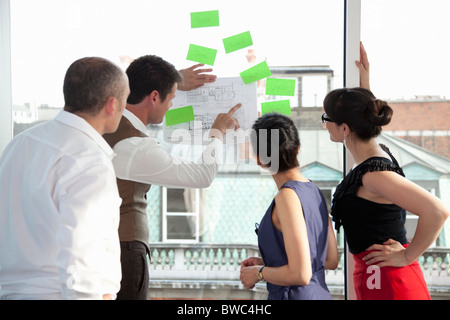 Arbeitskollegen, die Pläne zu betrachten Stockfoto