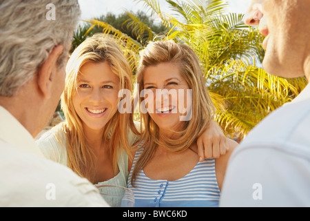 Mutter und Tochter im Gespräch mit zwei Männer Stockfoto