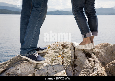 Mann und Frau stehen auf Felsen auf dem Seeweg Stockfoto