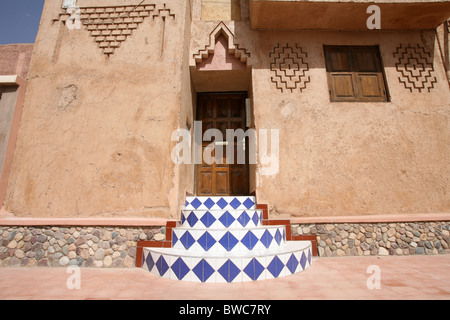 Farbige gefliesten Treppe zu einer hölzernen Tür in einer marokkanischen Stadt Stockfoto