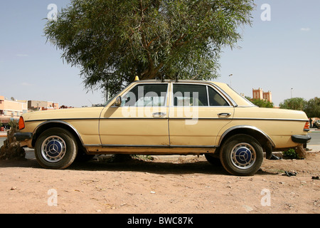 Ein Mercedes-Taxi in Marokko unter einem Baum geparkt Stockfoto