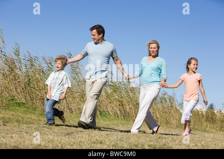 Familie mit jungen und Mädchen (8-9) zu Fuß in Feld Stockfoto