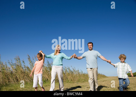 Familie mit jungen und Mädchen (8-9) zu Fuß in Feld Stockfoto
