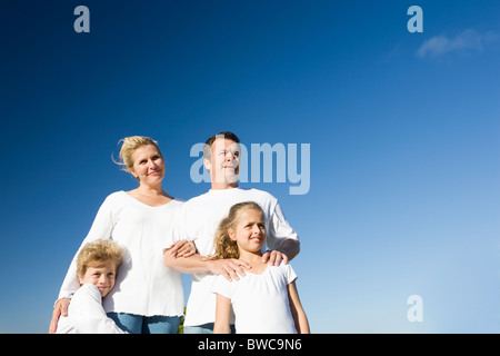 Familie mit jungen und Mädchen (8-9) gegen klar blauen Himmel Stockfoto