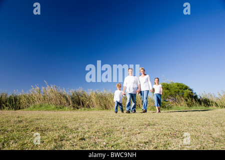 Familie mit jungen und Mädchen (8-9) zu Fuß auf der Wiese Stockfoto