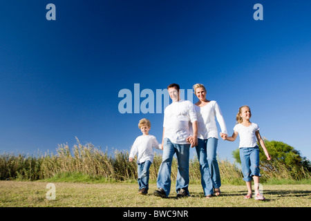 Familie mit jungen und Mädchen (8-9) zu Fuß auf der Wiese Stockfoto