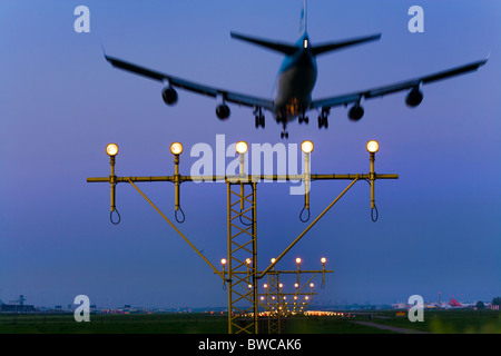 KLM Flugzeug Flugzeug nähert, Landung auf der Kaagbaan Landebahn des Flughafen Amsterdam Schiphol in der Abenddämmerung. Stockfoto