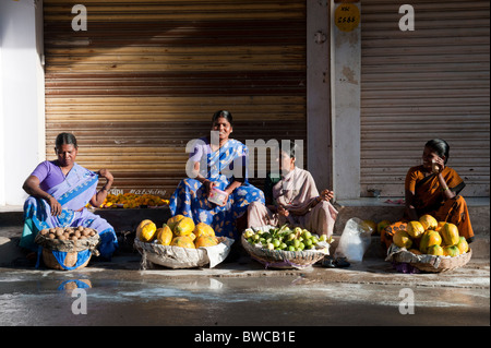 Indische Frauen verkaufen frisches Obst aus Körben in die Stadt Puttaparthi, Andhra Pradseh, Indien Stockfoto