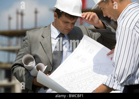 Bild von Geschäftsleuten Blick auf Dokument in Papierform in Händen des Auftragnehmers Stockfoto