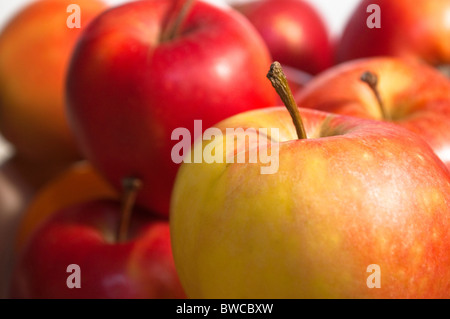 Nahaufnahme eines gelben, grünen und roten Apfel mit roten Äpfeln in soft-Fokus im Hintergrund. Stockfoto
