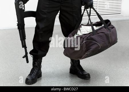 Bild der Beine der Einbrecher mit Tasche voll mit gestohlenem Geld in der hand Stockfoto