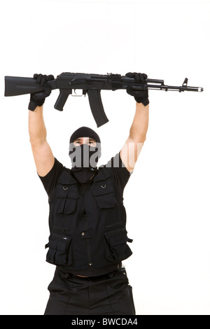 Porträt von Terroristen in Balaclava mit Gewehr über sich auf weißem Hintergrund Stockfoto