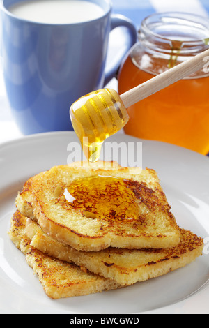 Gießen Honig auf Französisch Toast mit Honig dipper Stockfoto