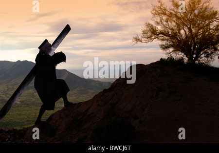 USA, Illinois, Metamora, Silhouette des Mannes mit Kreuz Hügel hinauf klettern Stockfoto