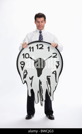 USA, Illinois, Metamora, Studioaufnahme des Kaufmanns halten schmelzende Uhr Stockfoto