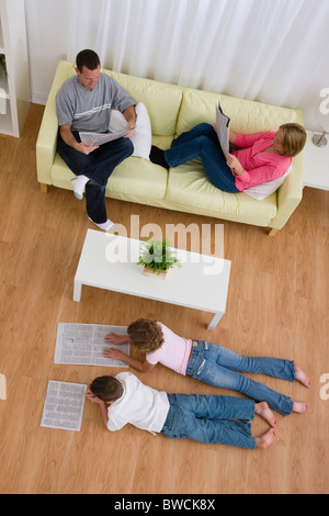 USA, Illinois, Metamora, Familie lesen Zeitungen im Wohnzimmer Stockfoto