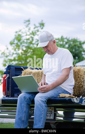 USA, Illinois, Metamora, Landwirt mit Laptop auf LKW Stockfoto