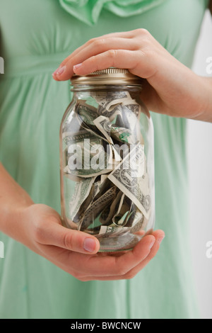 USA, Illinois, Metamora, Mittelteil Frau mit Glas mit Geld Stockfoto