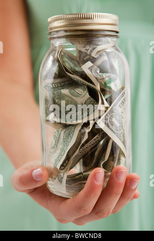 USA, Illinois, Metamora, Mittelteil Frau mit Glas mit Geld Stockfoto
