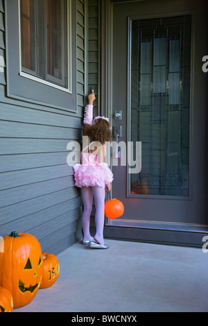 USA, Illinois, Metamora, Mädchen (6-7) im Halloween-Kostüm an Türen klopfen Stockfoto