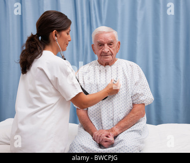 USA, Illinois, Metamora, Ärztin untersuchen senior Mann sitzt am Krankenhausbett Stockfoto