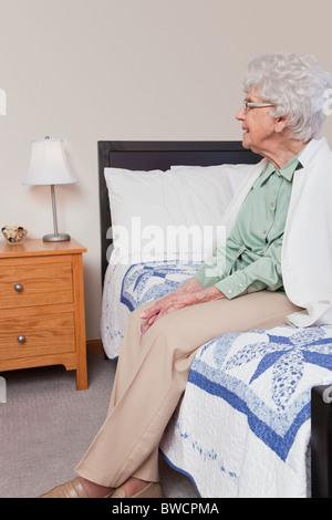 USA, Illinois, Metamora, Senior Frau sitzt am Bett Stockfoto