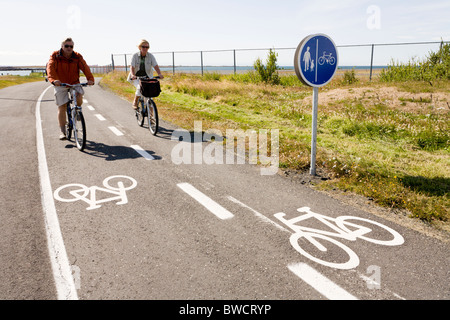 Menschen auf Fahrrädern entlang Nautholsvik Strand, Reykjavik Island. Stockfoto