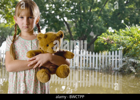 USA, Illinois, Metamora, Porträt von Mädchen (8-9) Holding Teddy im überfluteten Hof Stockfoto