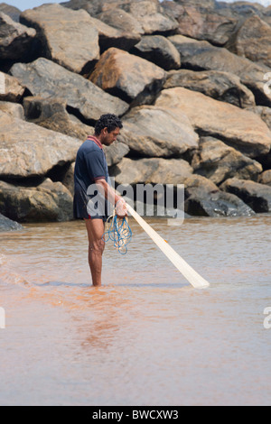 Sri Lanka Fischer sein Netz in seichtem Wasser abrufen Stockfoto