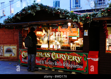 Kunden kaufen heißes Fleisch Roll auf einem Weihnachtsmarkt stall in Portsmouth England uk Stockfoto