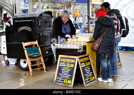 Frau verkaufen traditionelle gebackene Kartoffeln auf einem Weihnachtsmarkt in Portsmouth England uk Stockfoto