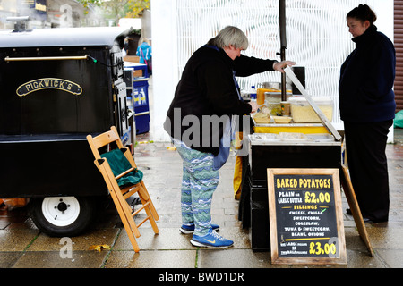 Frau verkaufen traditionelle gebackene Kartoffeln auf einem Weihnachtsmarkt in Portsmouth England uk Stockfoto