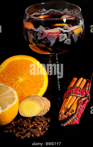 Traditionelle Glühwein in einer grünen ergab sich deutsche Glas, umgeben von den Zutaten: Orange, Zitrone, Zimt, Nelken, Ingwer. Stockfoto