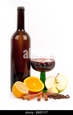Glühwein in einem Glas, umgeben von den Zutaten: Orange, Zitrone, Zimt, Nelken, Ingwer, Apfel. Auf weiß. Stockfoto
