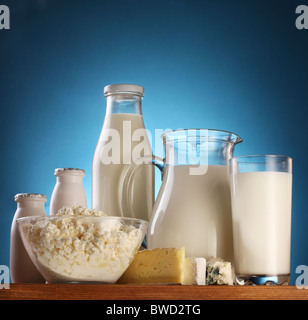 Verschiedene Milchprodukte: Käse; Creme; Milch. Auf einem blauen Hintergrund. Stockfoto