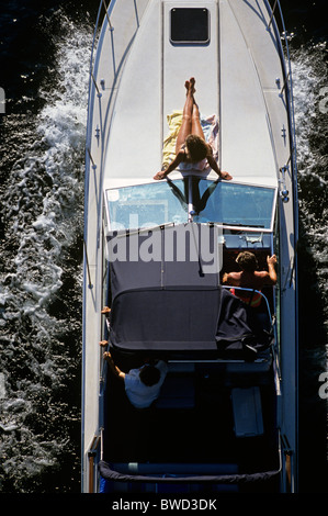 Eröffnungstag der Schifffahrt entlang der Montlake schneiden mit Frau sonnigen sich an Deck der Yacht Seattle Washington State USA Stockfoto