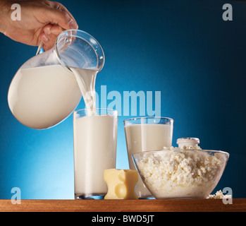 Milchprodukte. Hand des Menschen ist Milch aus Glas in Glas gießen. Stockfoto