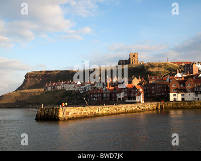 Whitby Hafen mit Hütten auf der Ostseite der Stadt und Str. Marys Kirche in der herbstlichen Sonne Stockfoto