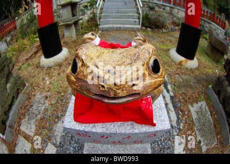 Kleinen Sub-Schrein in Fushimi Inari-Schrein mit einem glücklichen Kröte und roten Torii im Hintergrund, Kyoto, Japan Stockfoto