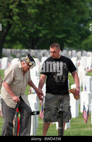 Ein Veteran zu Fuß durch den Grabstätten an Clement J Zablocki Veteranen Friedhof Wisconsin am Memorial Day mit einem jungen Mann Stockfoto