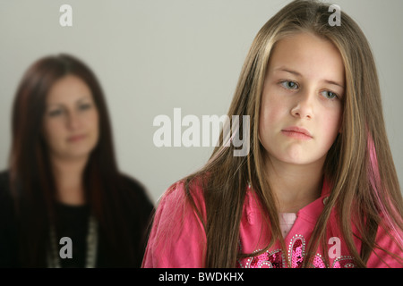 Ein trauriges zehn Jahre alten Mädchen mit ihrer Mutter im Hintergrund. Stockfoto