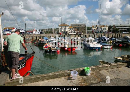 Angeln für Krabben aus dem Hafen Kai West Bay, einem beliebten Badeort auf West Dorset Jurassic Coast Stockfoto