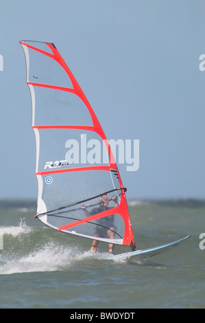 Ein Windsurfer fängt eine Welle an der Tampa Bay auf den Gewässern vor Fort Desoto Park in Tierra Verde, Florida. Stockfoto