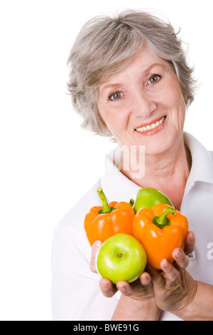 Porträt von gealterten weiblichen Holding Äpfeln und Paprika in Händen Stockfoto