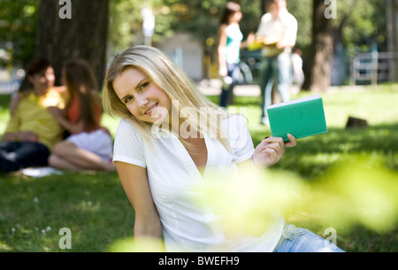 Porträt von fröhliches Mädchen mit Notebook in Händen, Blick in die Kamera in natürlicher Umgebung Stockfoto