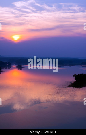 Die Sonne geht durch eine Schicht von Wolken über den Mississippi River in der Nähe von Savanne, IL. Stockfoto