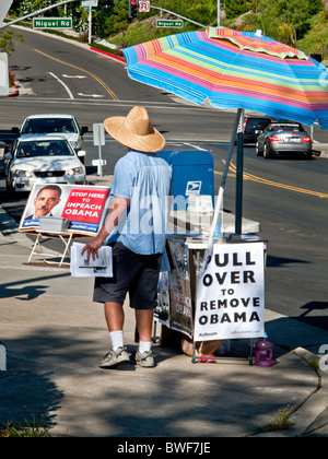 Ein Aktivist der Amtsenthebung von US-Präsident Barack Obama sucht verteilt Handzettel an vorbeifahrende Autofahrer in Laguna Niguel, CA. Stockfoto