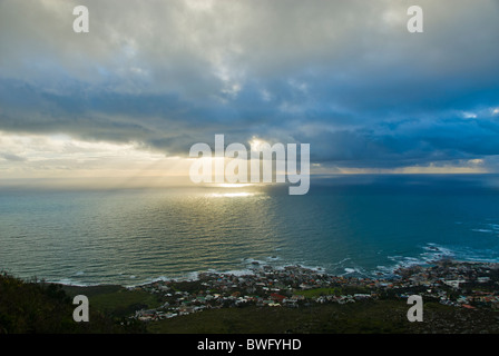 Sonnenstrahlen durchscheinen Gewitterwolken auf Meer Sonnenuntergang beherbergt Camps Bay im Vordergrund Camps Bay Cape Peninsula Western Cape Stockfoto