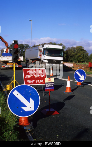 LKW vorbei durch Baustellen an temporären Bushaltestelle auf Straße in der Nähe von Leeds Yorkshire uk Stockfoto