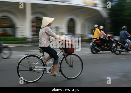 Radfahren auf Straße Hanoi mit traditionellen vietnamesischen Hut Frau Stockfoto